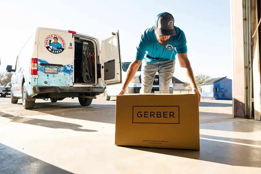 Justice Plumbing technician in Granbury, TX unloading equipment from service van, preparing for professional plumbing repair and installation services.