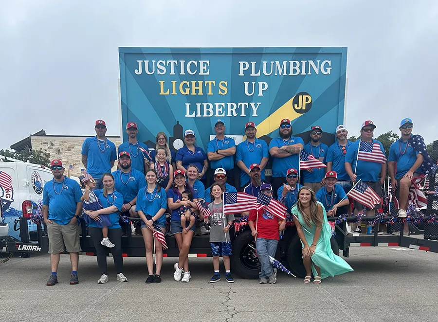 Justice Plumbing team at Granbury, TX parade float promoting local plumbing services, community involvement, and reliable home service professionals.