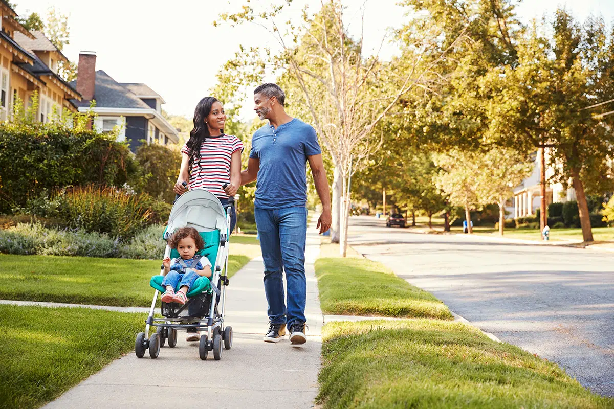 Mom and Dad push daughter in stroller through Granbury TX neighborhood