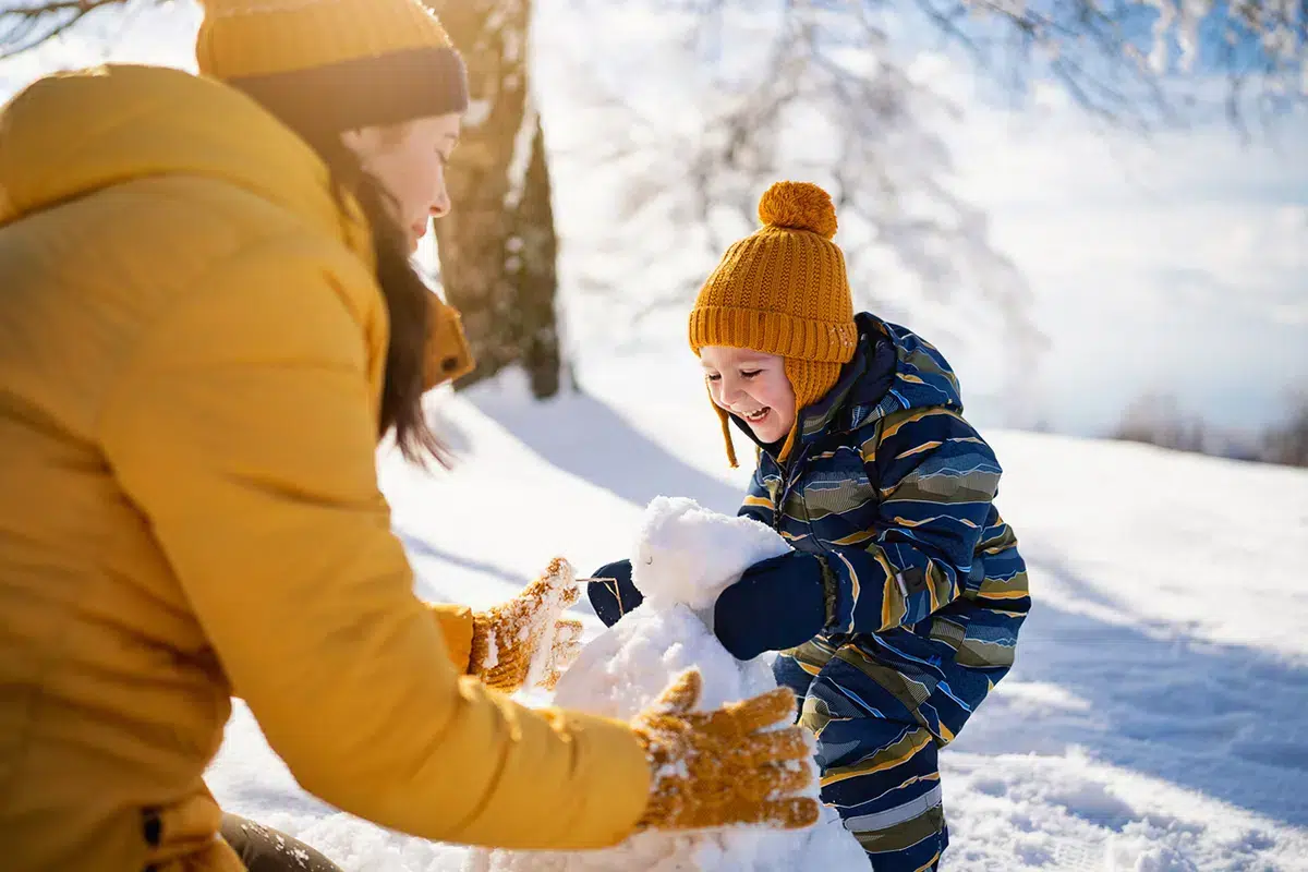 mom and kid playing in snow
